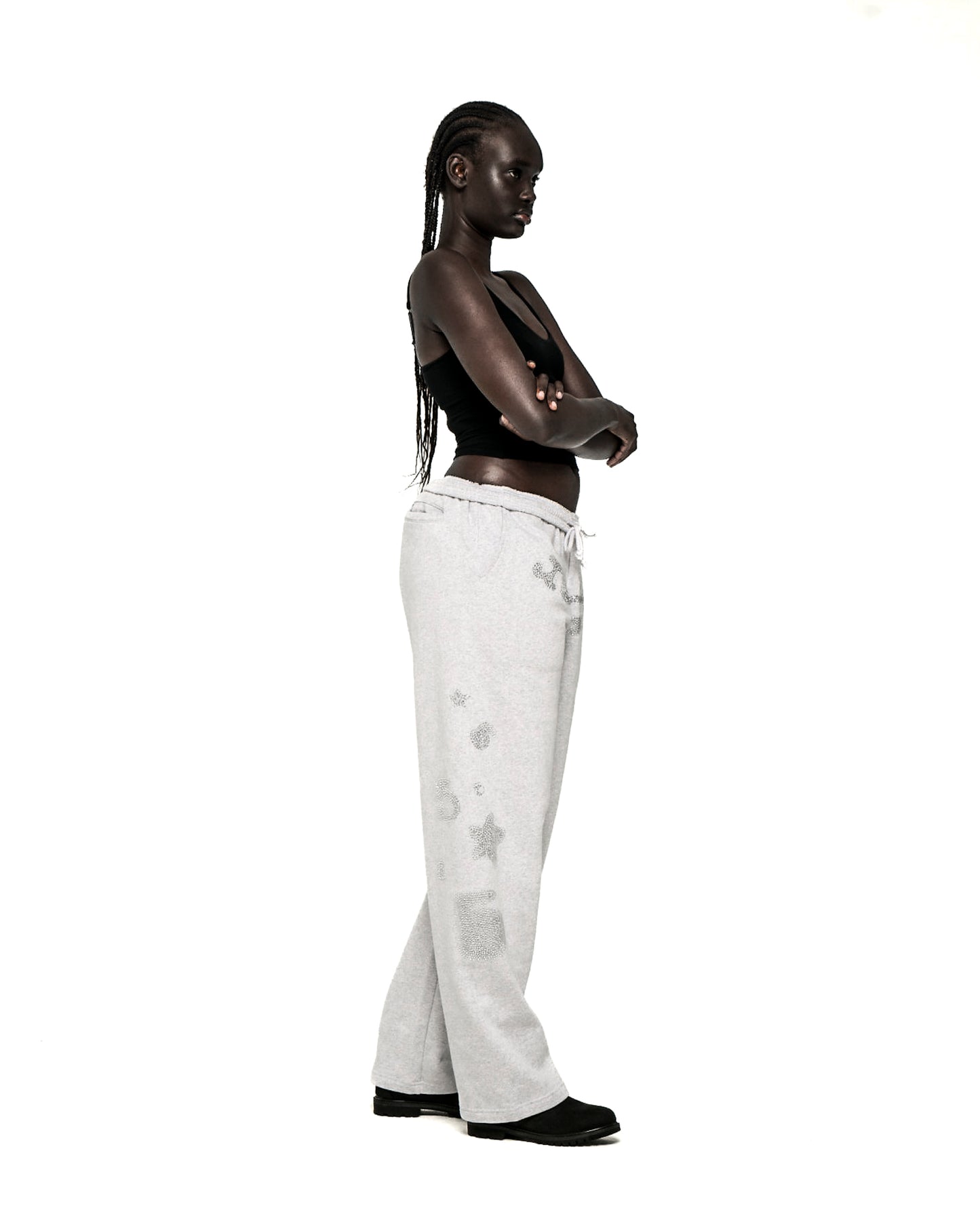 Light grey wide-leg sweatpants with rhinestone 'SP5DER' text, '5', and star designs.