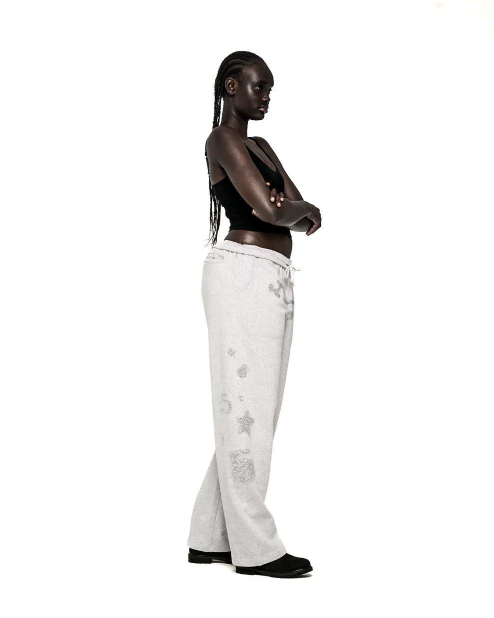 Light grey wide-leg sweatpants with rhinestone 'SP5DER' text, '5', and star designs.