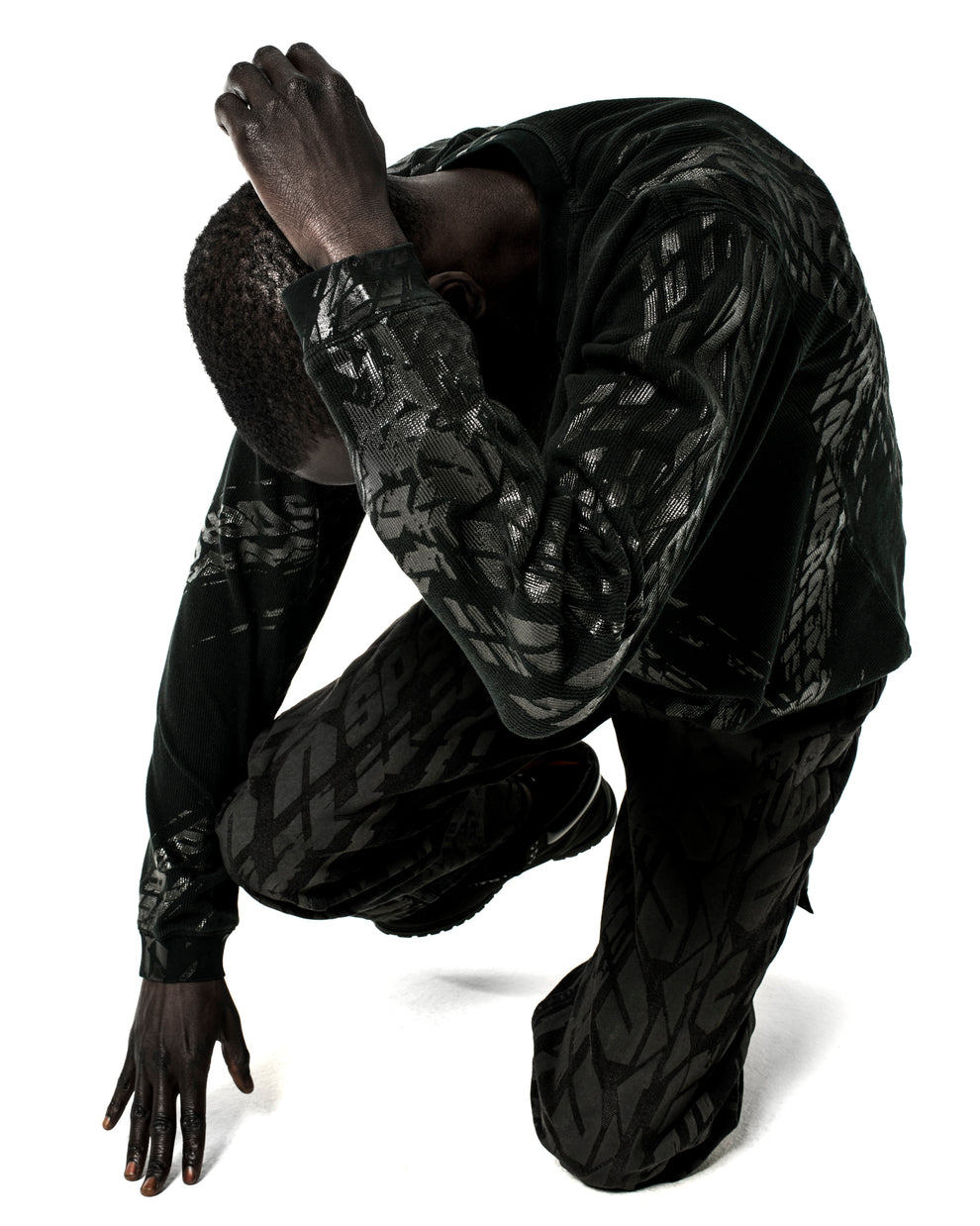 Black waffle knit thermal shirt and pants with all-over tire track print.