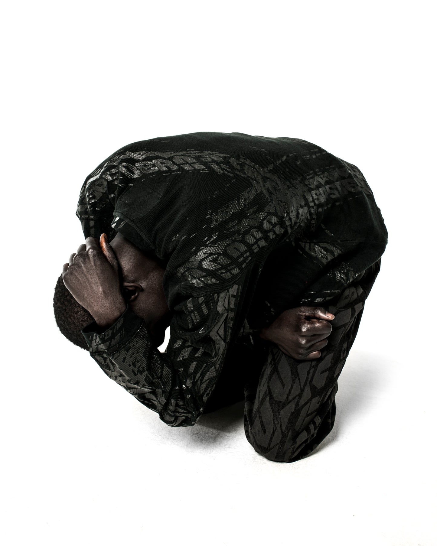 Black waffle knit thermal with ribbed collar, hem, and cuffs, featuring an all-over tire track print.