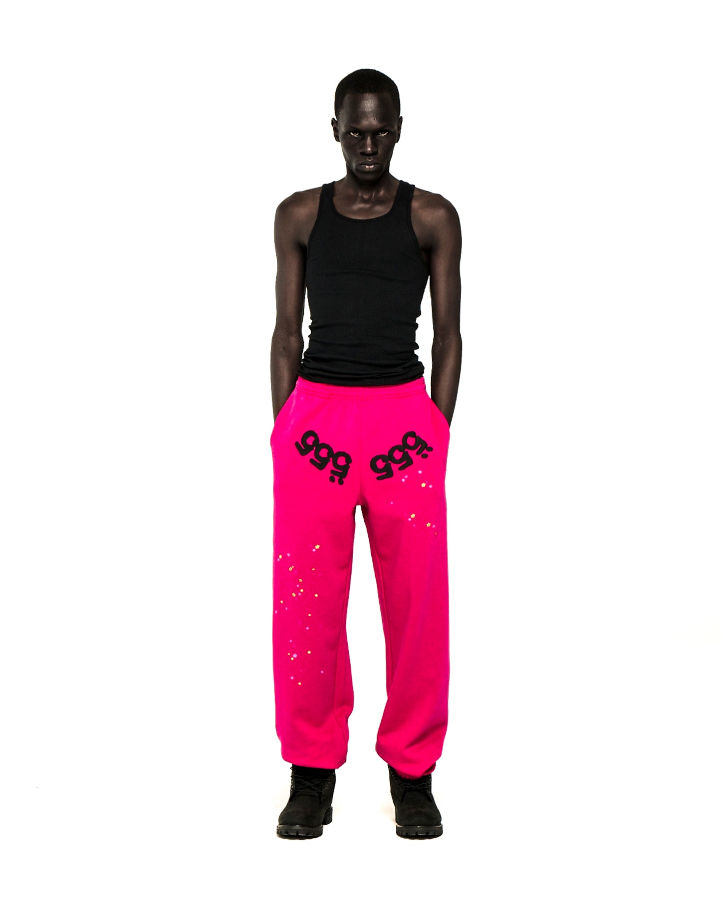 Model in hot pink ANGEL NUMBER SWEATPANTS with black '555' puff print and scattered stars.