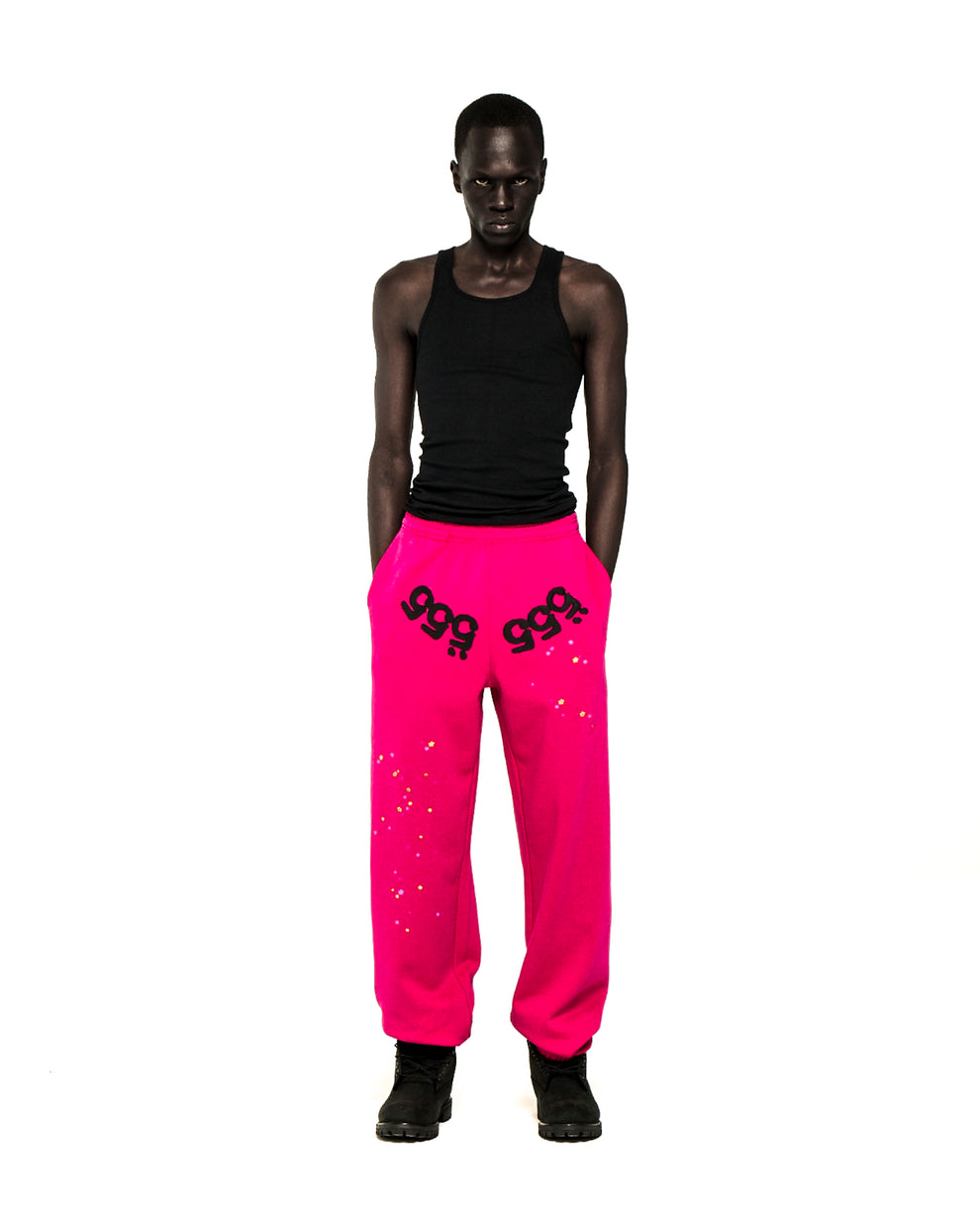 Model in hot pink ANGEL NUMBER SWEATPANTS with black '555' puff print and scattered stars.