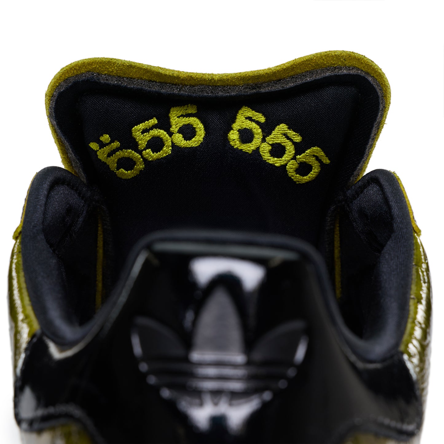 SP5DER x ADIDAS SUPERSTAR with glossy black cracked patent leather and embroidered "555" on the olive green tongue lining.