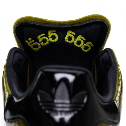 SP5DER x ADIDAS SUPERSTAR with glossy black cracked patent leather and embroidered "555" on the olive green tongue lining.