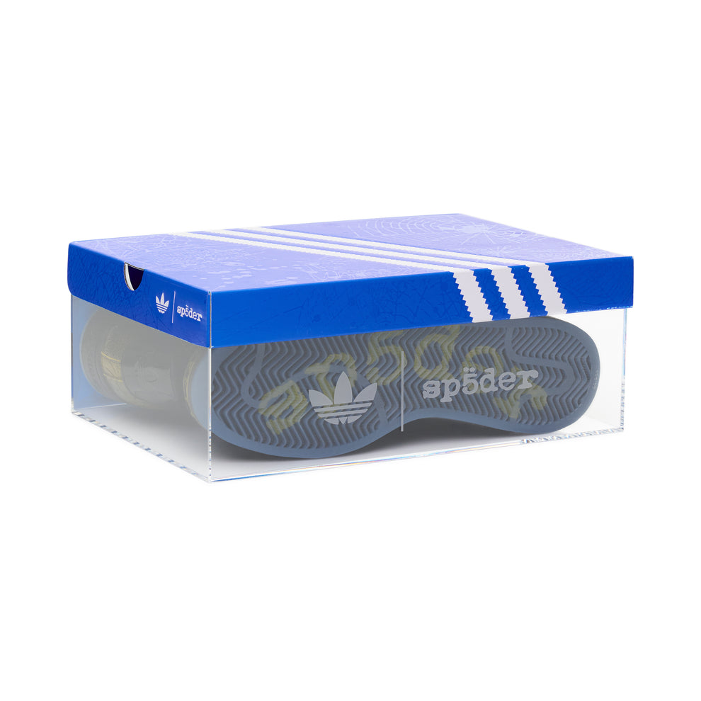 SP5DER x Adidas Superstar shoe in clear display box, showing blue outsole with "sp5der" logo.