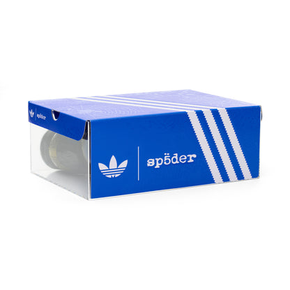 Blue SP5DER x ADIDAS SUPERSTAR shoebox with white stripes and logo, clear plastic front.