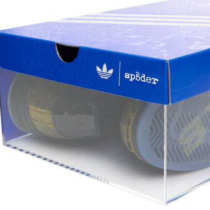 SP5DER x ADIDAS SUPERSTAR in a clear display box with a blue lid featuring Adidas and Sp5der logos.