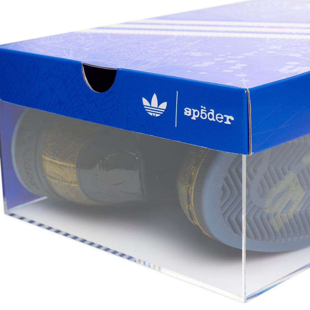 SP5DER x ADIDAS SUPERSTAR in a clear display box with a blue lid featuring Adidas and Sp5der logos.