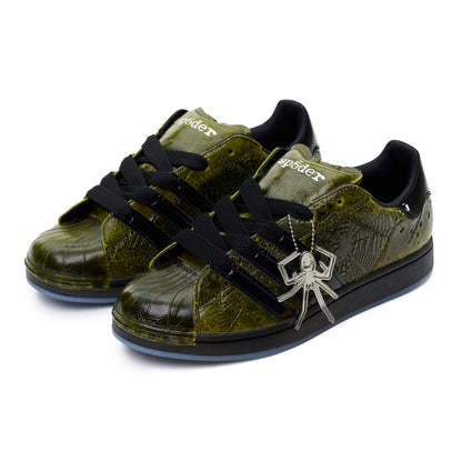 SP5DER x ADIDAS SUPERSTAR sneakers with glossy cracked olive patent leather, black laces, spider charm, and black stripes.