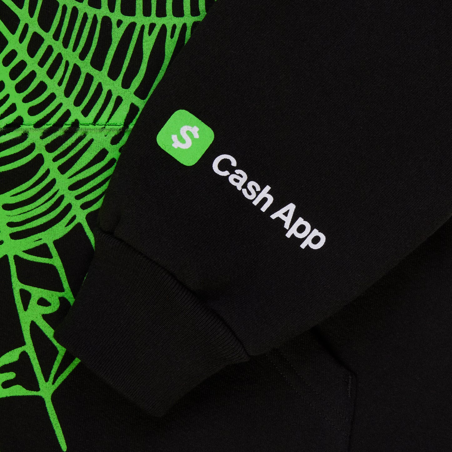 Black cotton fleece hoodie with green rhinestone-lined phantom web print and Cash App logo on sleeve.