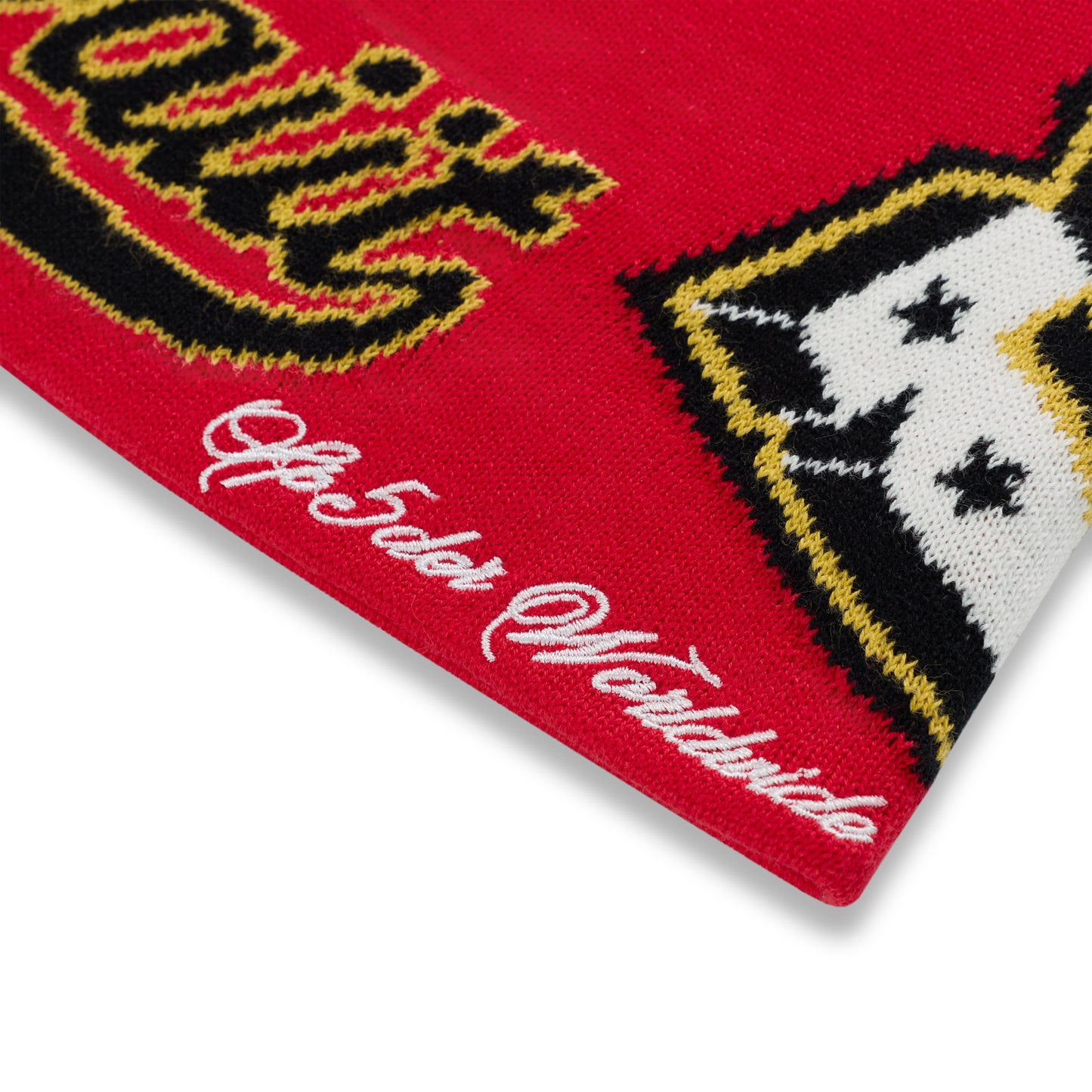 Red acrylic DISTRICT V SKULLY beanie with black, yellow, and white varsity graphic details and white embroidered text.