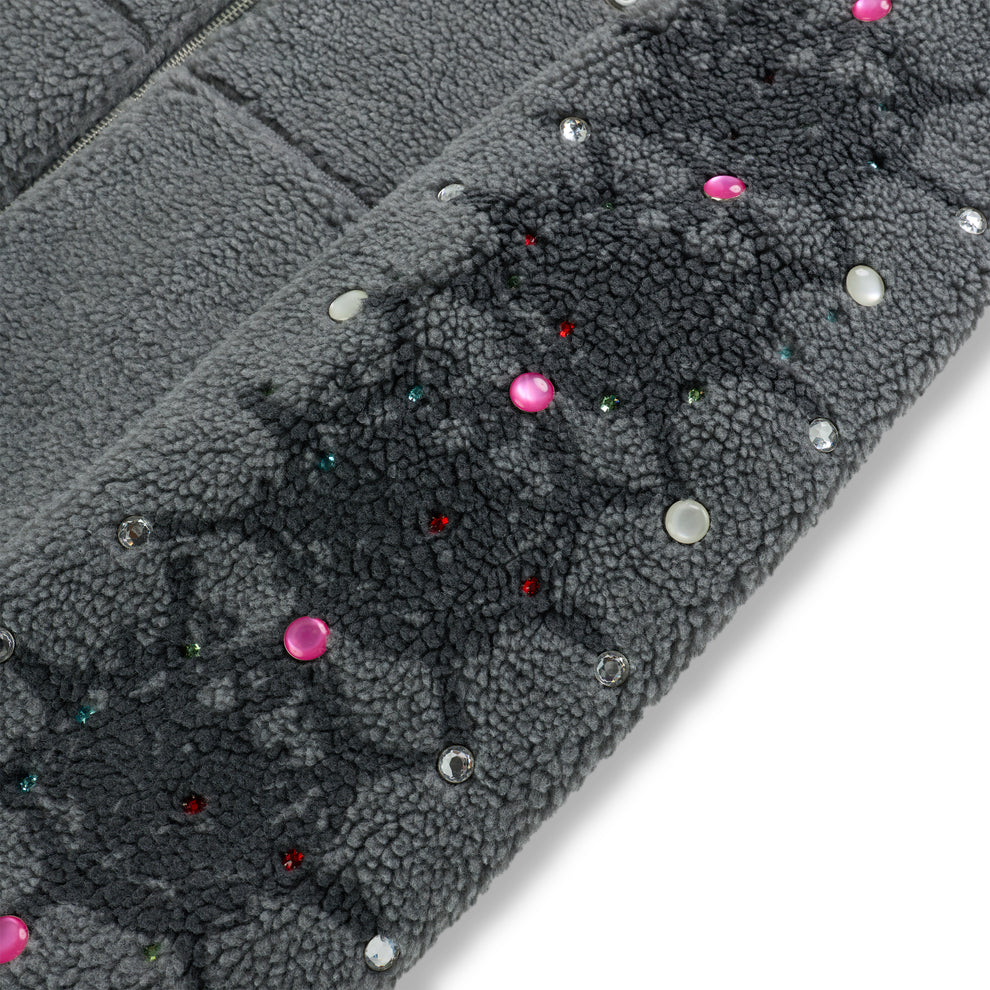 Gray sherpa fleece zip-up jacket sleeve with colorful rhinestone and pearl embellishments.
