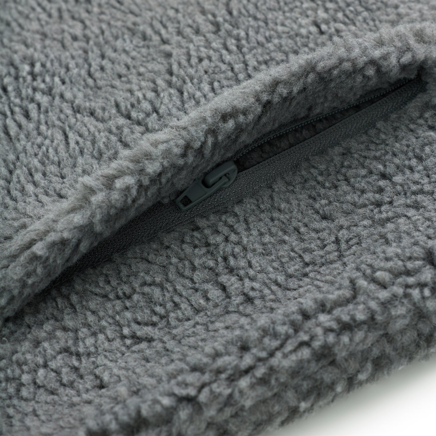 Close-up of gray sherpa fleece jacket with a dark gray zipper detail.
