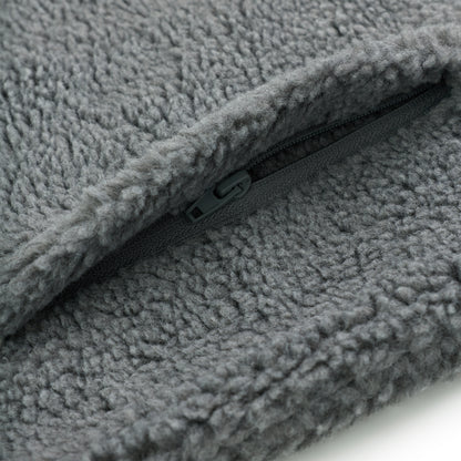 Close-up of gray sherpa fleece jacket with a dark gray zipper detail.