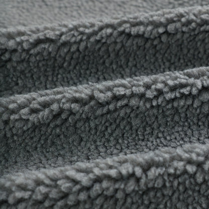 Close-up of soft, textured gray sherpa fleece fabric, folded in waves.