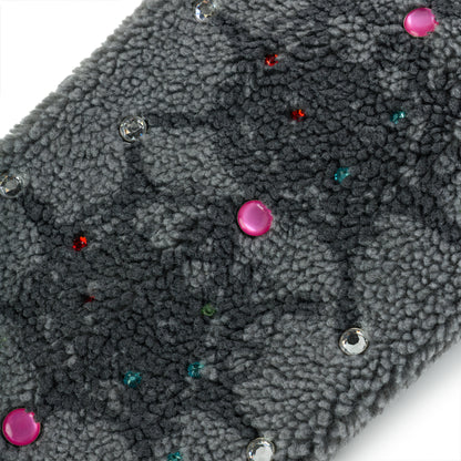 Close-up of gray sherpa fleece with scattered pink, clear, red, and teal rhinestone embellishments.