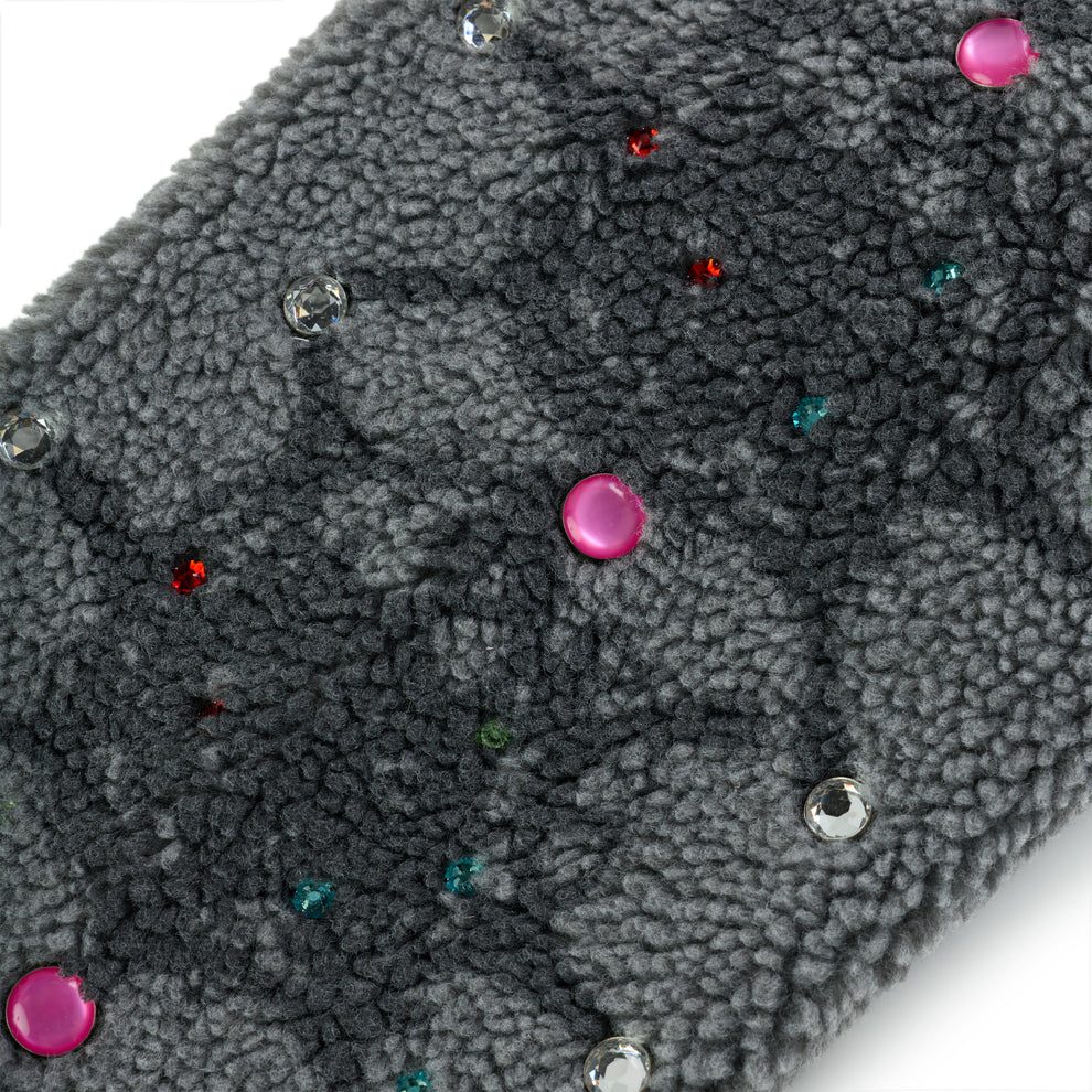 Close-up of gray sherpa fleece with scattered pink, clear, red, and teal rhinestone embellishments.