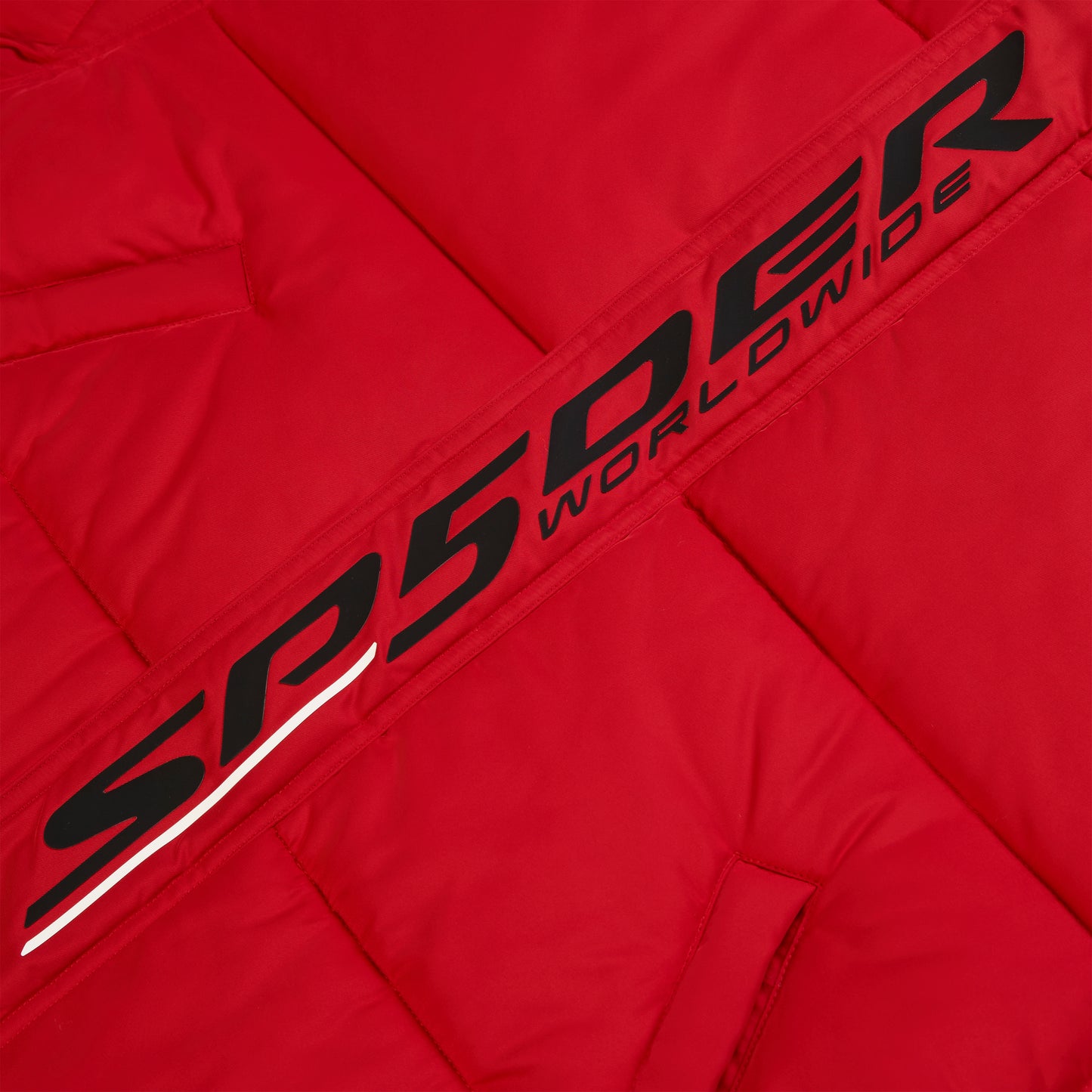 Red poly-fill puffer jacket with black "SPYDER WORLDWIDE" reflective text graphic along the front placket.