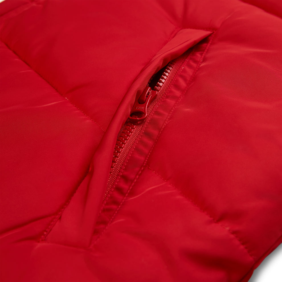 Red poly-fill TRACKHAWK puffer jacket with a visible zippered chest pocket.