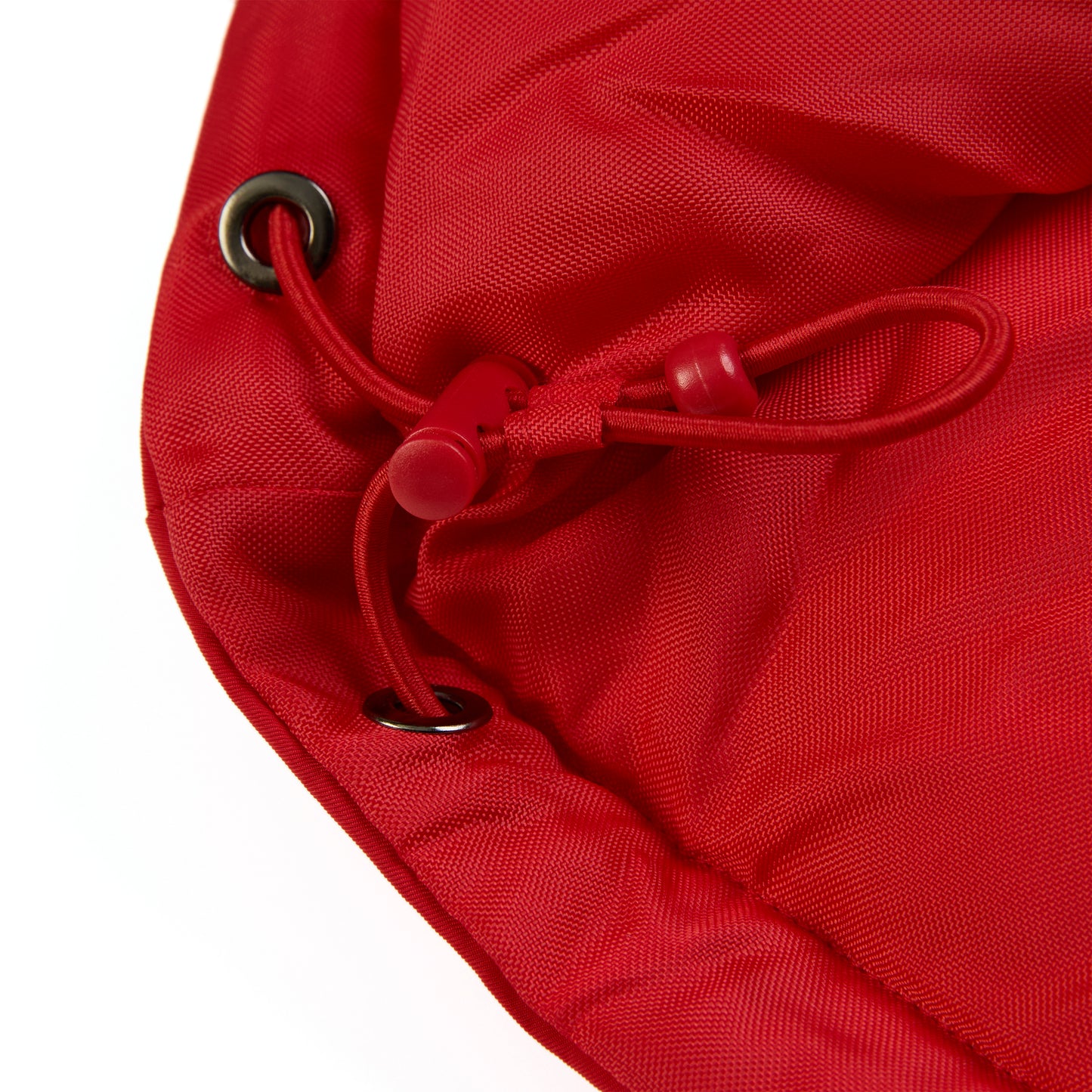 Close-up of a red poly-fill puffer jacket hem with internal drawstring and black grommets.