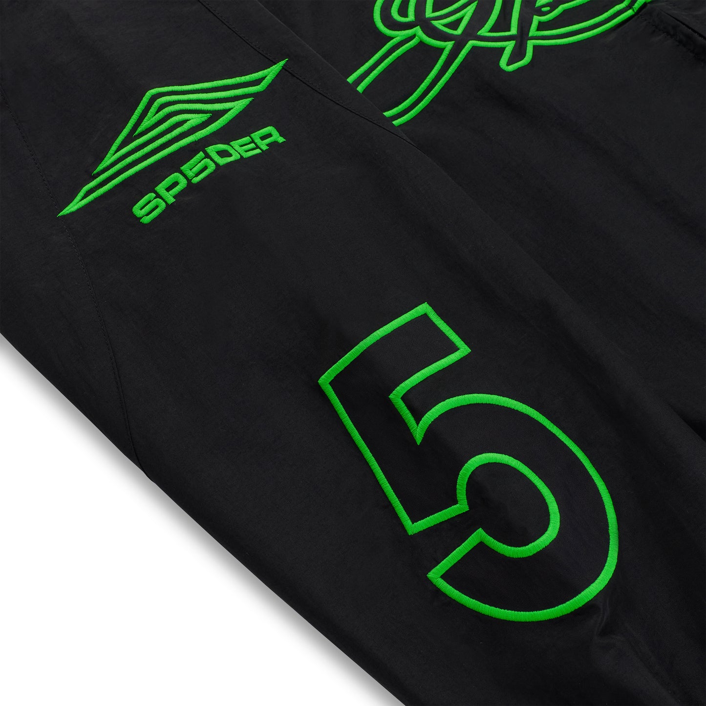 Black nylon track jacket sleeve with green embroidered "SP5DER" logo and large "5" graphic.
