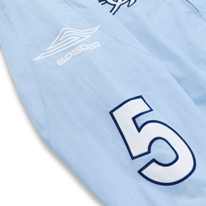 Light blue nylon track jacket sleeve with white "SP5DER" logo and large navy "5" graphic.