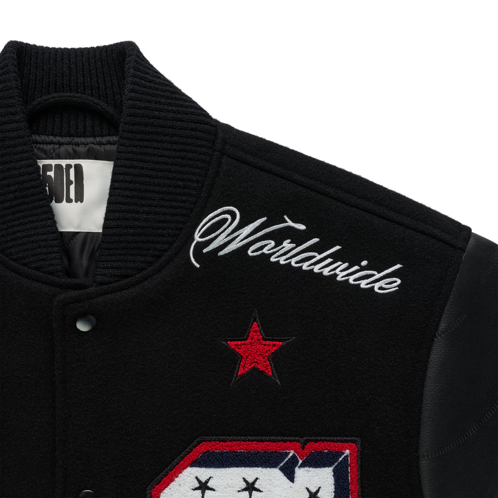 Black wool varsity jacket with leather sleeves, "Worldwide" embroidery, red star patch, and ribbed collar.
