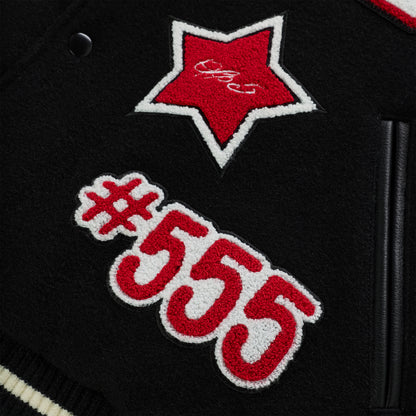 Black wool varsity jacket with red and white embroidered star and "#555" patches, leather trim.