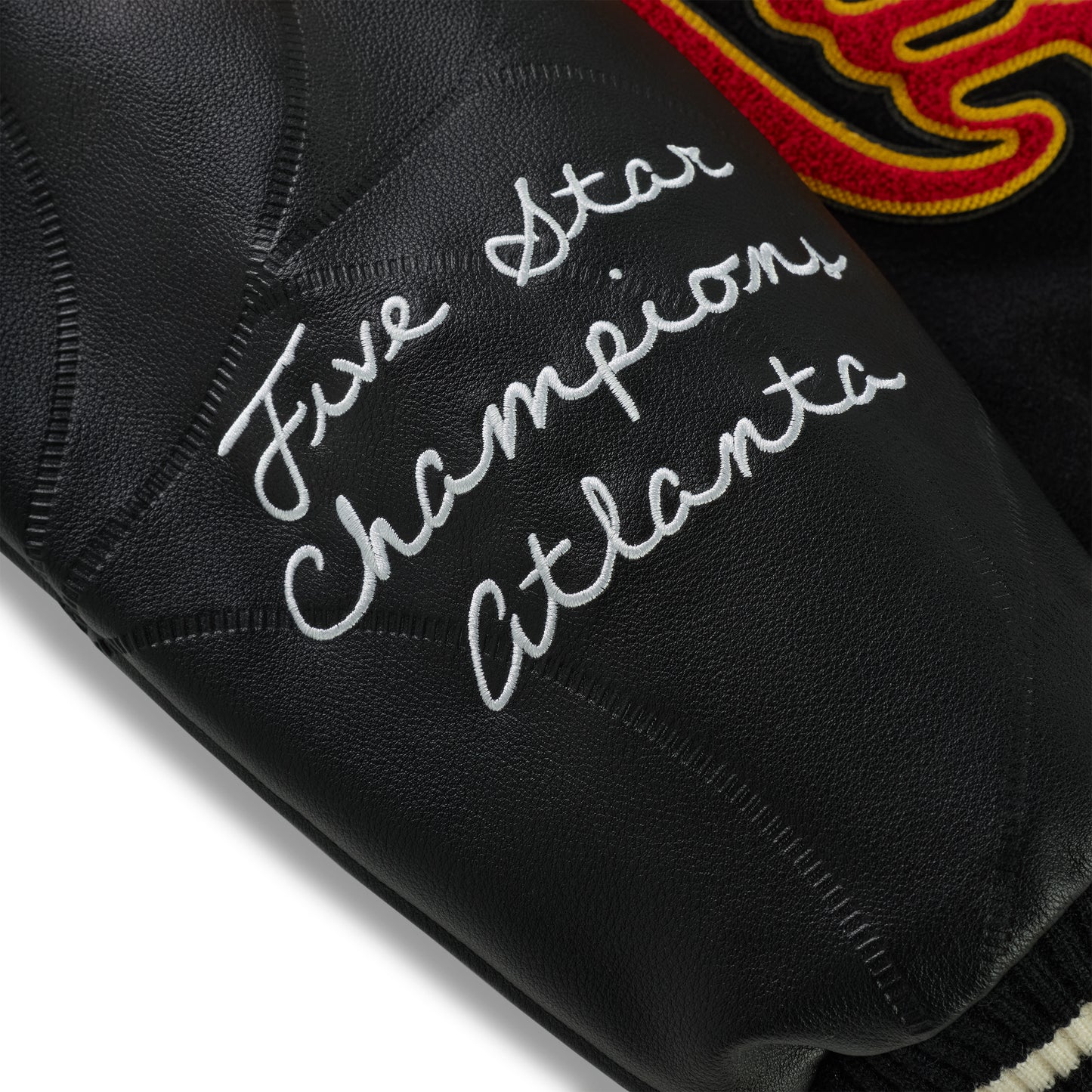Black leather varsity jacket sleeve with "Five Star Champions Atlanta" embroidery and debossed web design.