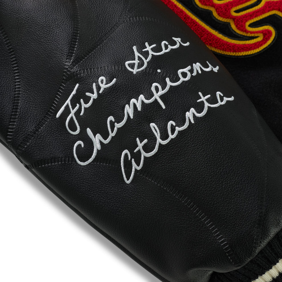 Black leather varsity jacket sleeve with "Five Star Champions Atlanta" embroidery and debossed web design.