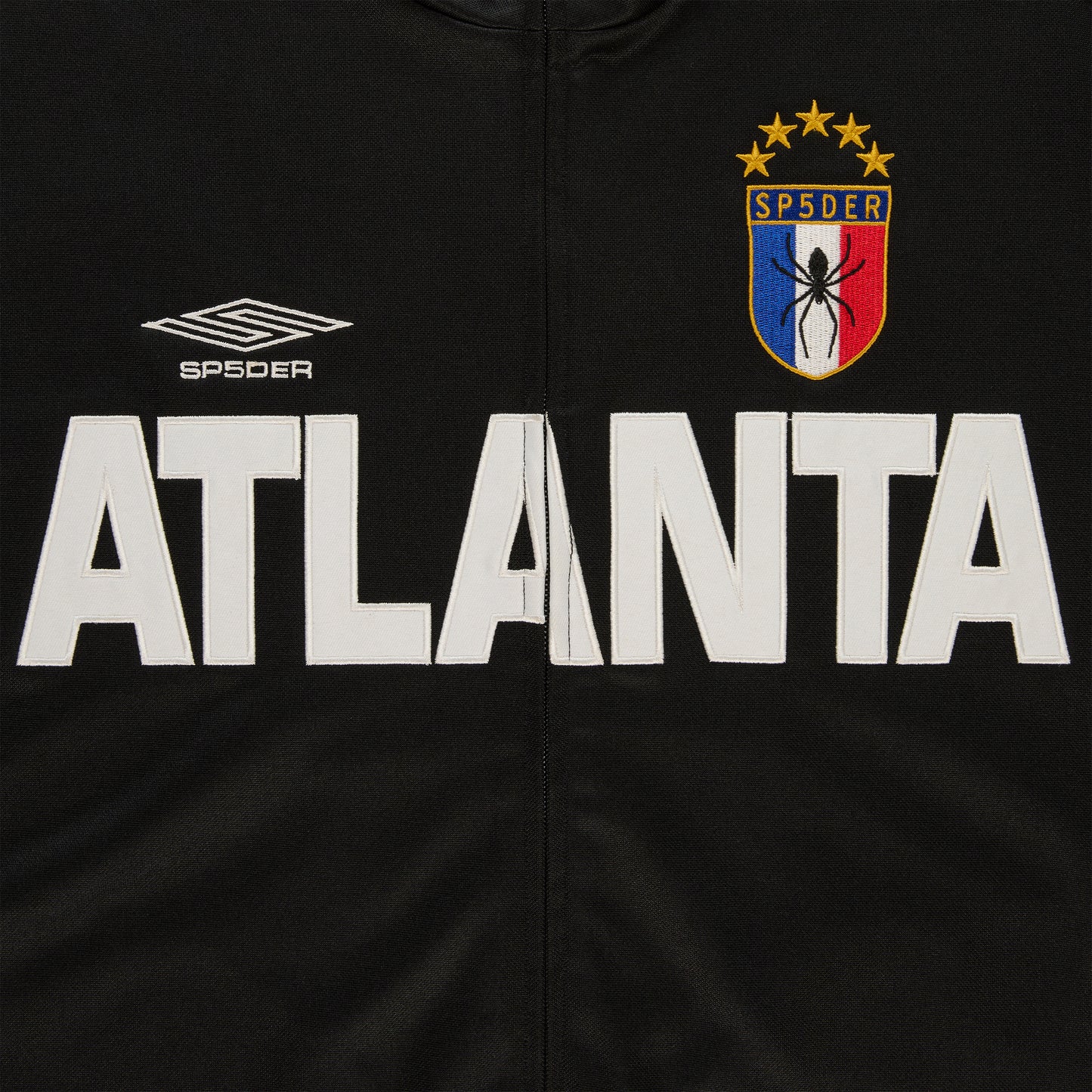 Black polyester ATLANTA Track Jacket with white lettering, SP5DER crest, and Umbro logo.