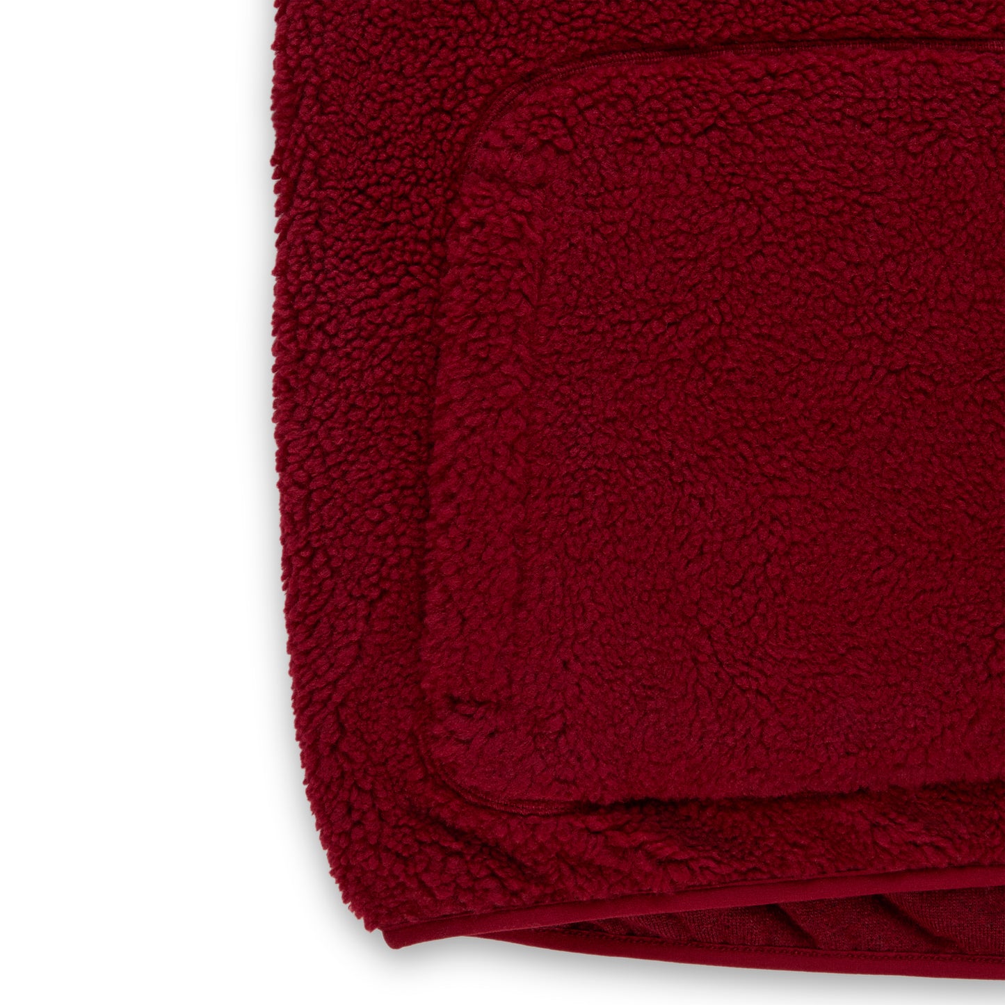 Close-up of a deep red teddy fleece zip-up jacket with a welt pocket and soft, textured sherpa material.