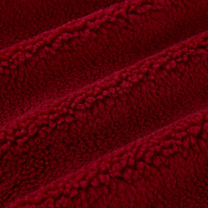 Close-up of plush red teddy sherpa fleece fabric with soft, textured loops and gentle folds.