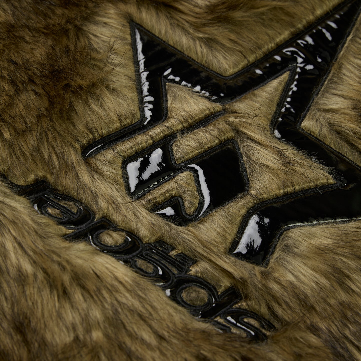 Brown faux fur jacket with glossy black patent leather star design and "NOCTURNAL" text.