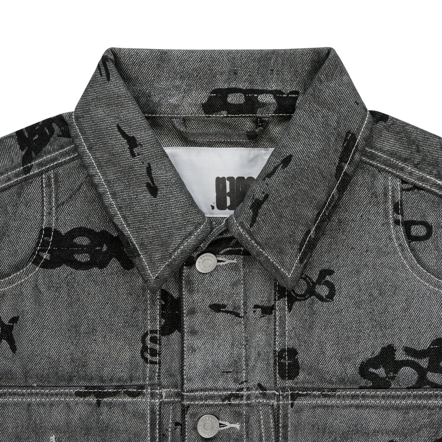 Gray denim trucker jacket with black all-over print, spread collar, silver buttons, and red contrast stitching.