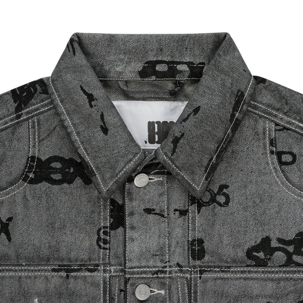 Gray denim trucker jacket with black all-over print, spread collar, silver buttons, and red contrast stitching.