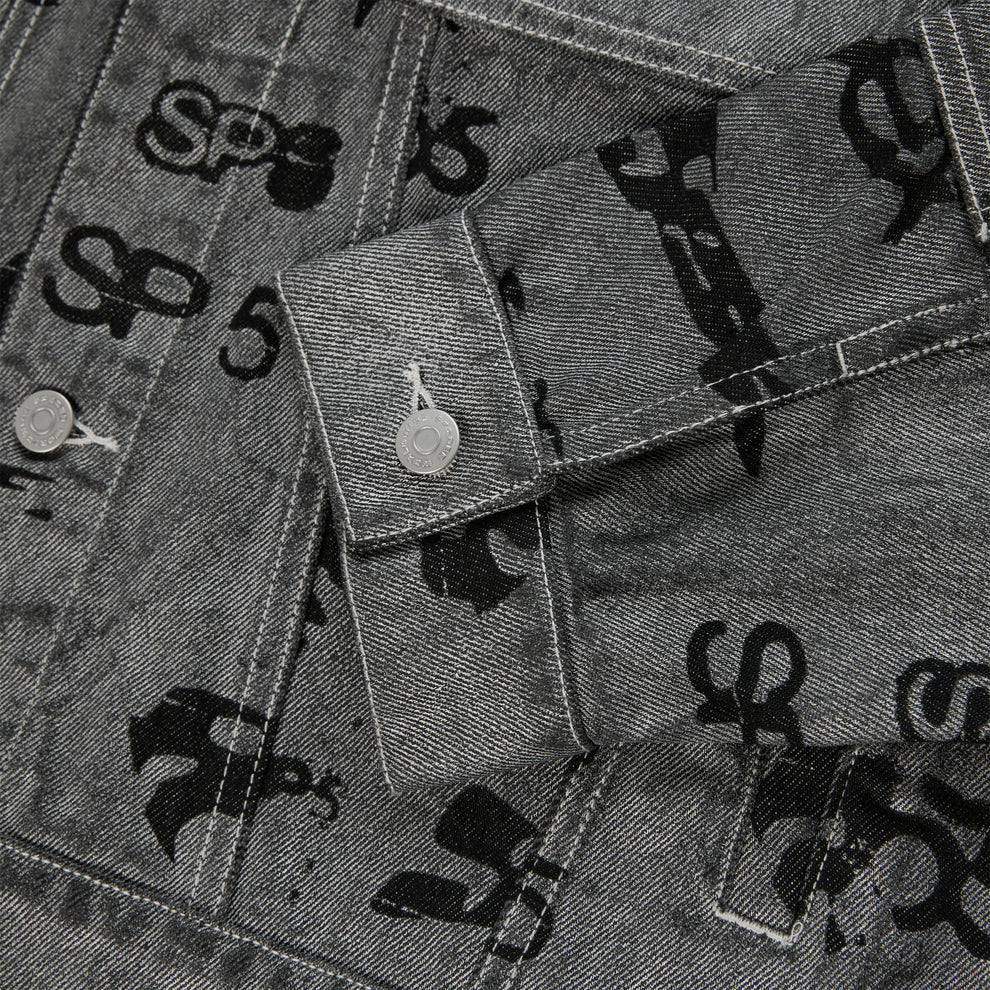 Gray denim trucker jacket with black all-over print, silver buttons, and red contrast stitching.
