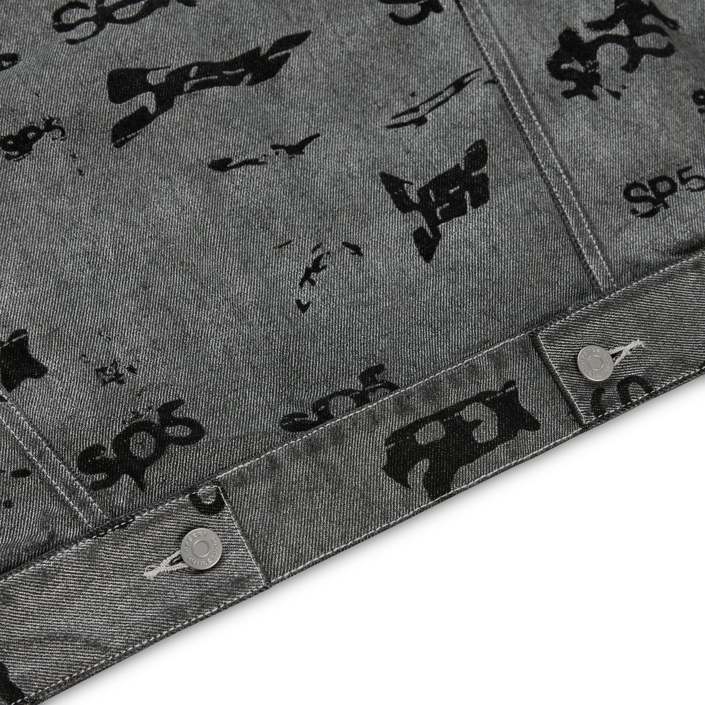Gray denim trucker jacket with all-over black foil print and silver button closures.