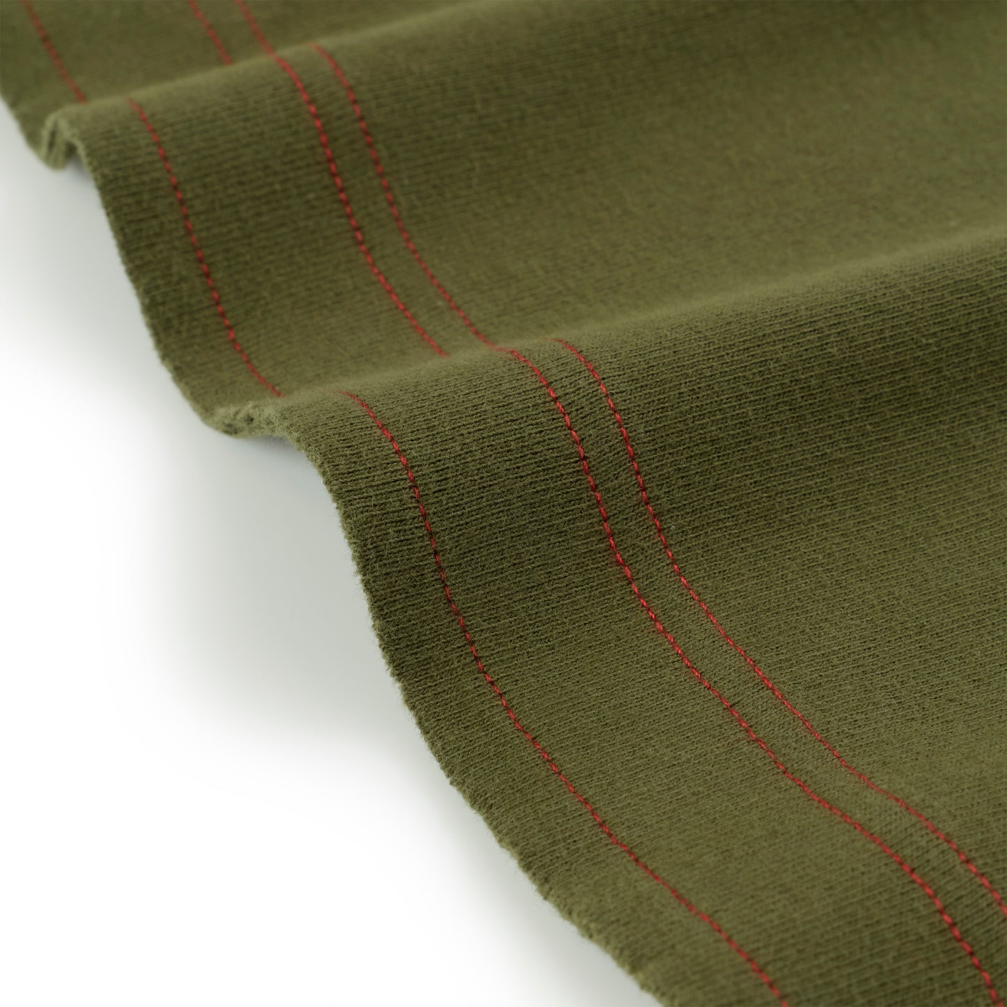 Olive green knit fabric with red stitching detail, folded on white background.