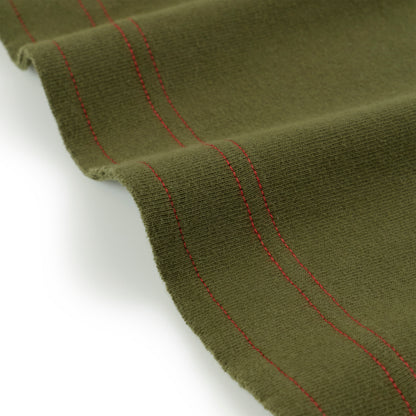 Olive green knit fabric with red stitching detail, folded on white background.