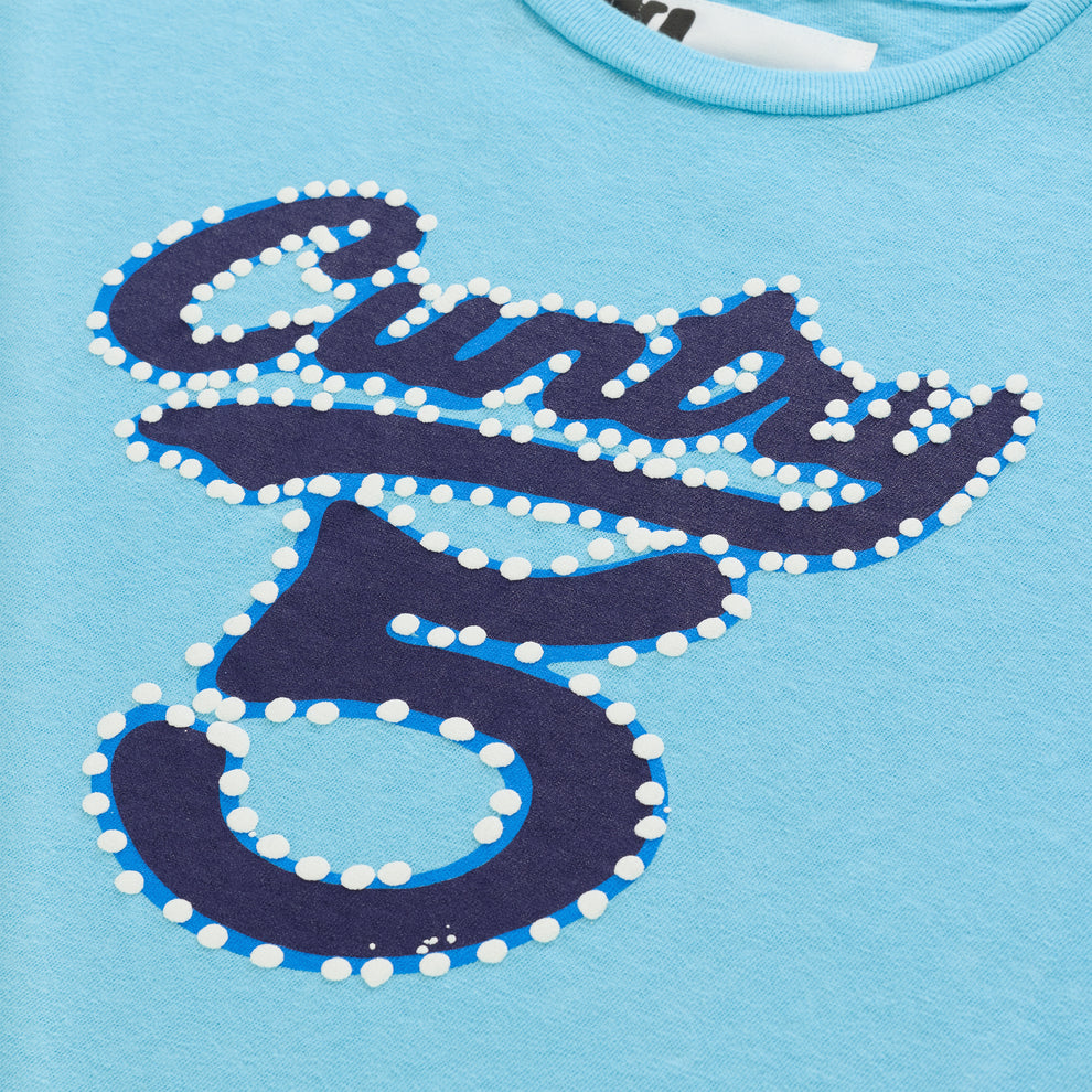 Light blue cotton/spandex cropped tee with "CUNTRY 5" graphic in dark blue with white raised dots.