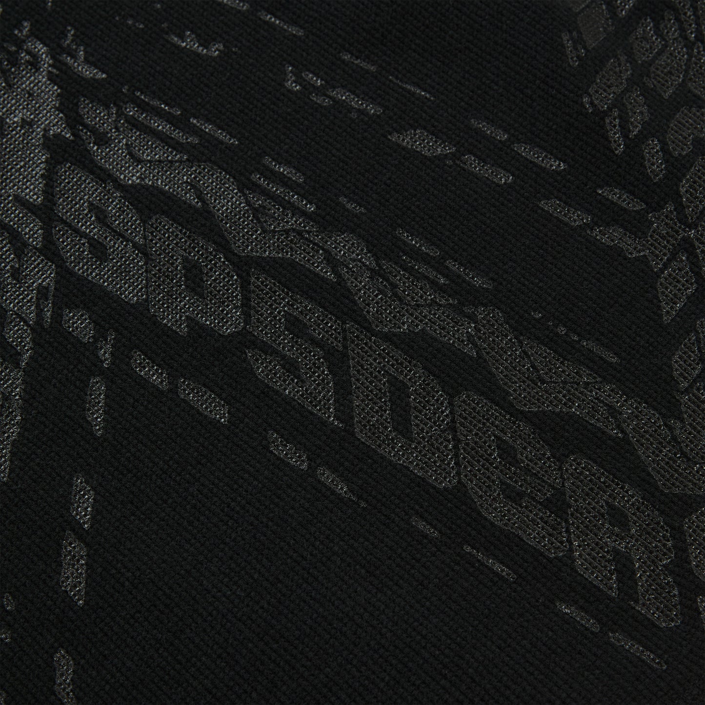 Close-up of black waffle knit thermal with subtle tire track print.