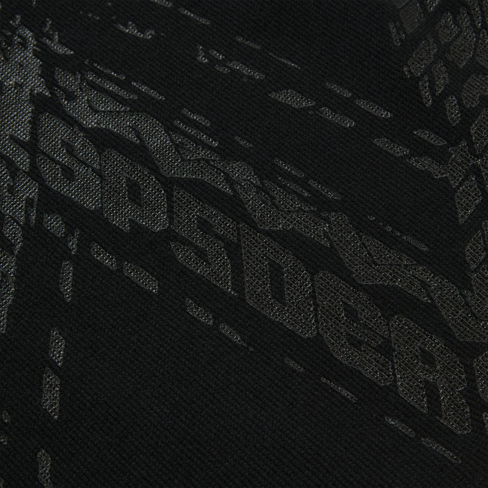 Close-up of black waffle knit thermal with subtle tire track print.