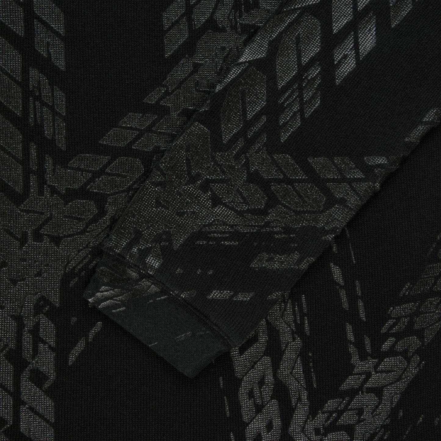 Black waffle knit thermal with subtle tire track print, ribbed cuff.