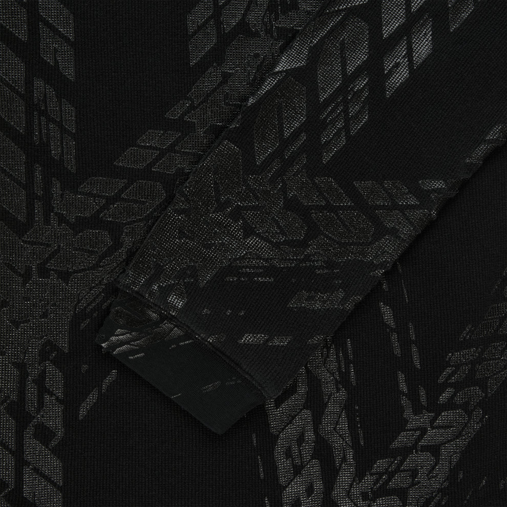 Black waffle knit thermal with subtle tire track print, ribbed cuff.