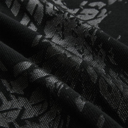 Close-up of a black waffle knit thermal with an all-over tire track print.
