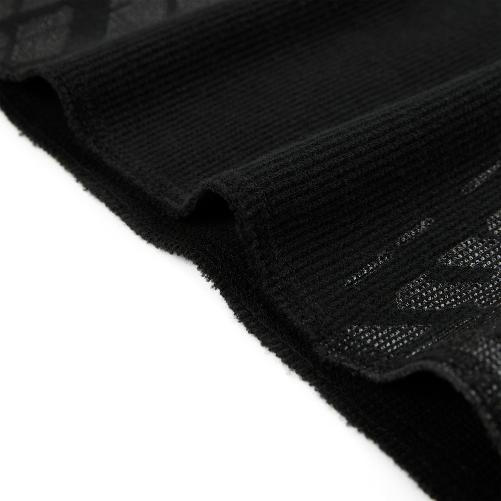 Black waffle knit thermal with ribbed details and subtle tire track print.