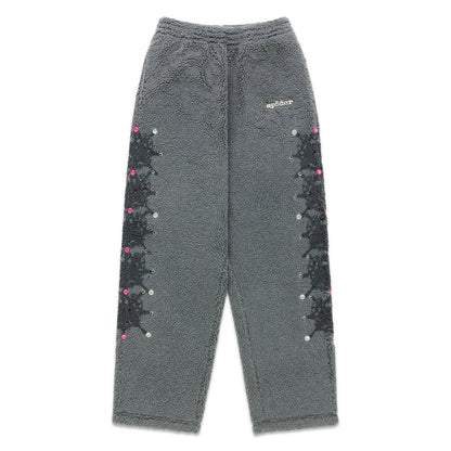 Gray sherpa fleece pants with rubberized logo, web print, and rhinestone embellishments down both legs.