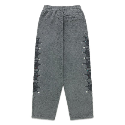 Gray sherpa fleece pants with web print and rhinestone embellishments down both legs.