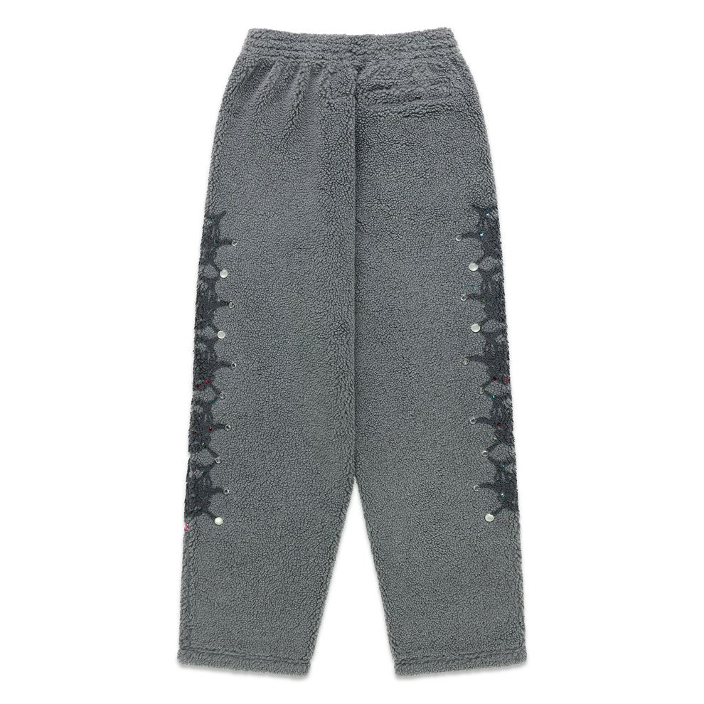 Gray sherpa fleece pants with web print and rhinestone embellishments down both legs.